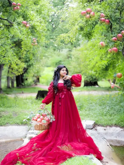 A duplicate of image 70, this storybook outdoor portrait shows the mom-to-be in a red gown in a beautiful apple orchard.
