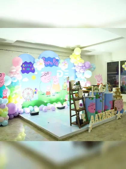 A wide shot of the Peppa Pig setup, giving a sense of the space and the overall cheerful atmosphere of the party.
