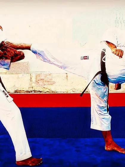 A student holds a kicking shield for me during a demonstration. This drill builds resilience and teaches students how to both deliver and absorb powerful techniques safely.