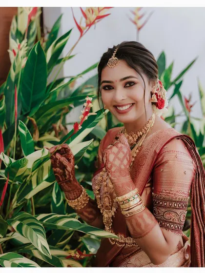 A beautiful close-up of the bride, her smile radiant, surrounded by greenery.