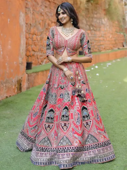 A full-length view of our red lehenga with distinctive black and silver embroidery. The A-line skirt and matching jacket-style blouse create a flattering and modern silhouette.