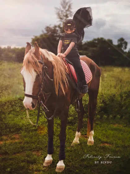 Not all heroes wear capes, but this one does! A four-year-old Batman enjoying a ride on his trusty steed.