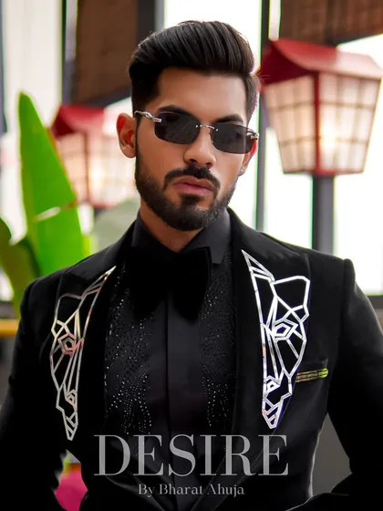 A powerful portrait in the black velvet tuxedo. The geometric embroidery on the lapels adds a unique, artistic touch to a classic piece.