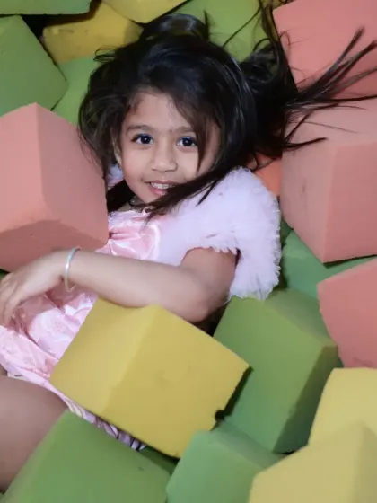 A happy face emerges from our foam block pit. This area is great for building, climbing, and tumbling safely.