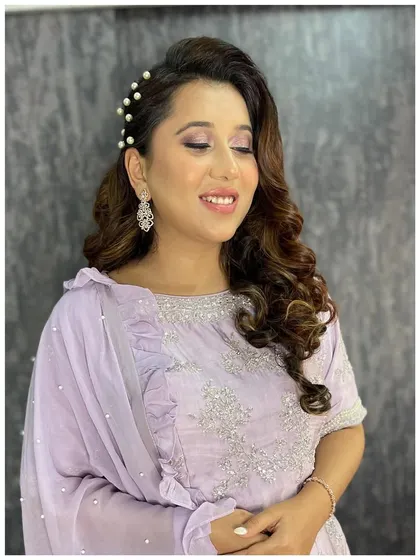 A side view of this lovely lavender look. The pearl hair accessories are placed to add a touch of elegance and draw attention to her beautifully styled soft curls.