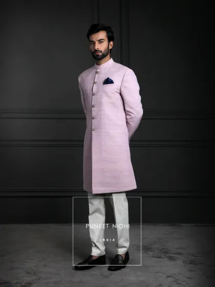 A simple yet elegant lavender Achkan in rich silk, styled with a sleek straight fit and mandarin collar. This piece blends quiet grandeur with refined craftsmanship.