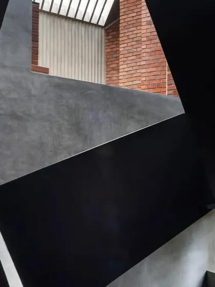 An abstract, geometric composition of the staircase at the Brick House, highlighting the interplay of form and material.