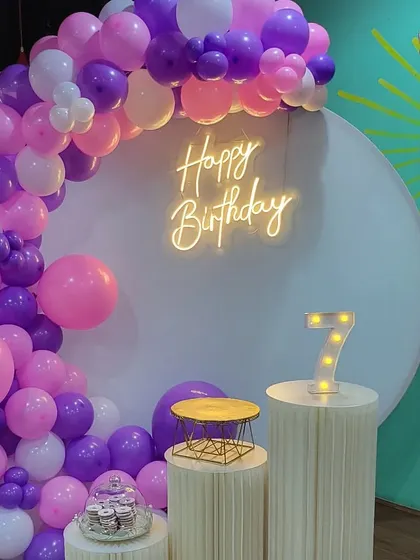 A close-up of the balloon arch and neon sign.