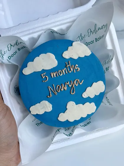 Celebrating 5 months with this dreamy sky-themed mini cake. The blue buttercream is adorned with fluffy white clouds and a message written in gold.