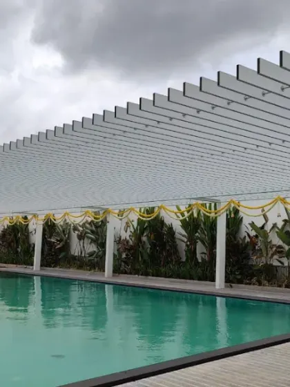 Shaded sophistication meets poolside perfection. This sleek white pergola provides a structured yet open-air covering for a tranquil swimming pool area.