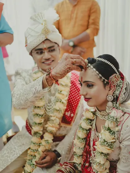 The groom applies sindoor to the bride's forehead, one of the most significant rituals in a Hindu wedding. I capture these moments with reverence and care.