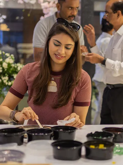 An event comes alive when guests are engaged. Here, a guest participates in an interactive workshop during the GKB Opticals relaunch, surrounded by the welcoming atmosphere we helped create.