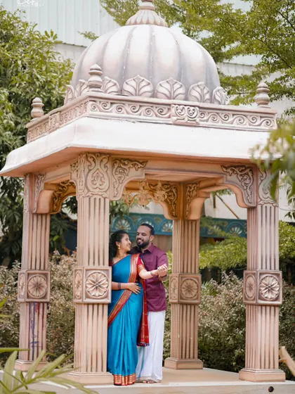This couple looks regal in their traditional outfits, posing inside a beautifully detailed gazebo. We ensure every element, from costume to location, is perfect.