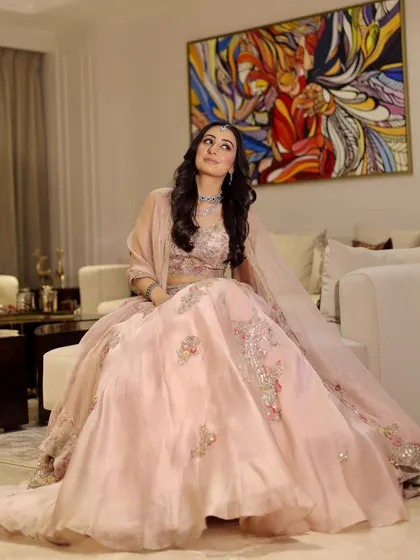 A full-length portrait showcasing the beautiful pink lehenga and the makeup that completes the look.