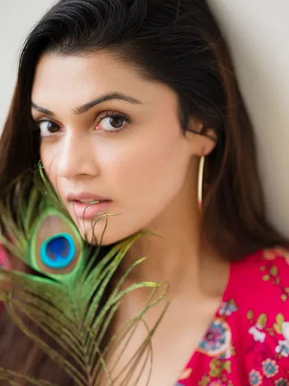 A creative portrait using a peacock feather. The close-up on the face is intimate, and the feather adds a touch of color and symbolism.