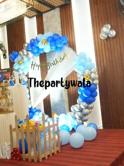 Another view of a blue and silver balloon ring, showing the full setup on a stage.