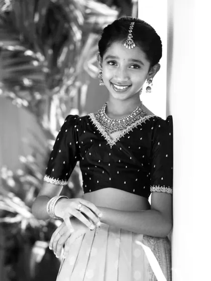 A beautiful black and white portrait of one of the sisters, highlighting the delicate embroidery on her custom blouse.
