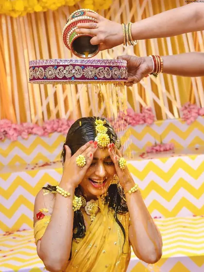 Capturing the pure joy of the Haldi ceremony. The bride is showered with flowers and turmeric, and my decor with its bright yellow drapes and floral accents creates a perfectly festive atmosphere.