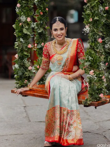 A beautiful portrait of the bride on a flower-adorned swing. The makeup is soft and romantic, perfect for this whimsical setting.