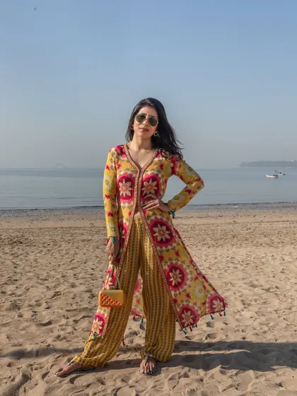 A vibrant yellow and pink printed co-ord set featuring a long jacket and striped pants. This is a great Rakhi outfit option if you want something modern, colorful, and eye-catching.