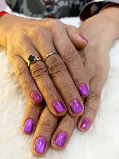 This look showcases the magical effect of cateye gel polish. I applied this shimmering purple cateye polish over natural nails for a client's special event. The magnetic polish creates a deep, shifting line of light that is truly captivating.