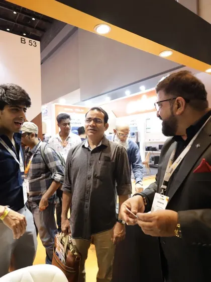 An exhibitor shares a business card with an interested attendee, a classic yet vital part of the networking and lead generation process at our B2B event.