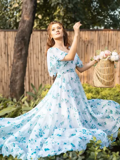 A full-length portrait showcasing the beautiful train of the dress against a natural, green backdrop. This is a perfect shot for a brand's lookbook.