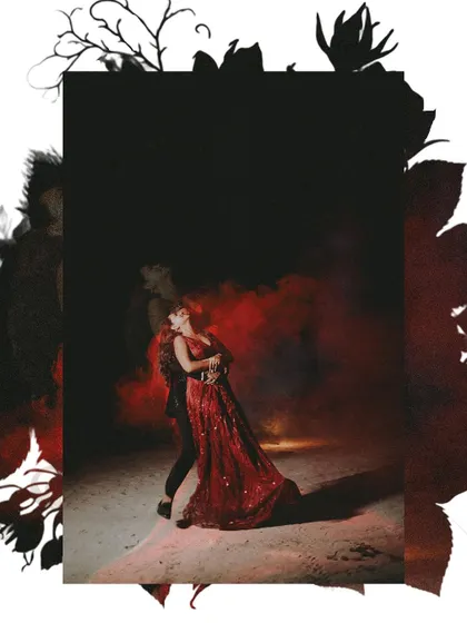 A dramatic pre-wedding shot using red smoke for a bold, passionate effect. The couple is captured in a dance-like pose, creating a powerful and cinematic image.