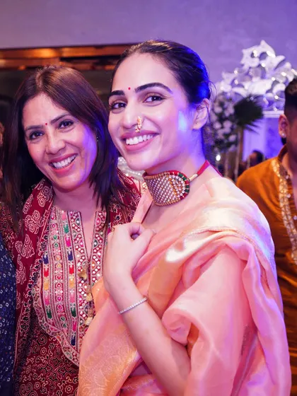 A happy moment with my mother. For this event, I wore a light peach organza saree with a unique choker, showing how modern jewelry can style a traditional outfit.