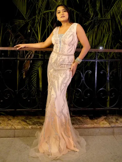 A glamorous look in a peach gown for an evening gala. I believe the host's attire should match the elegance and prestige of the awards night.