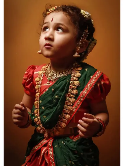 An angelic upward-looking shot of the little girl in her traditional attire.