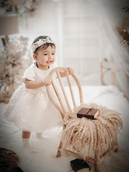 An angelic portrait in a soft, dreamy, all-white setting. This high-key, ethereal style creates a timeless and beautiful memory.