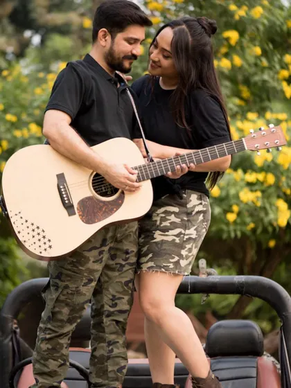 An outdoor pre-wedding shoot with a musical theme. The natural setting and shared activity create a romantic and candid feel.
