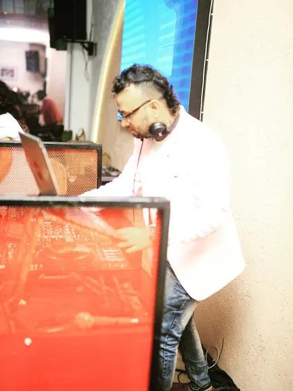 Leaning into the mix, fully absorbed in the music and the technical flow of the set.