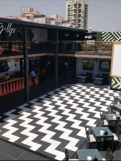 For this commercial project, we designed a multi-level hospitality space with a bold, graphic identity. The black and white chevron flooring creates a high-energy focal point for the entire venue.