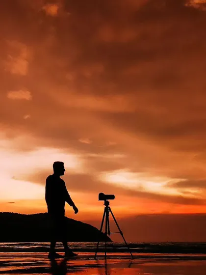 A silhouette of me with my camera on a tripod, setting up a shot against a beautiful beach sunset. This is where I feel most at home, behind the lens.