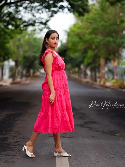 Taking over the street for a moment to capture this beautiful shot. The empty road acts as a perfect leading line, drawing all the attention to her and the vibrant pink dress.