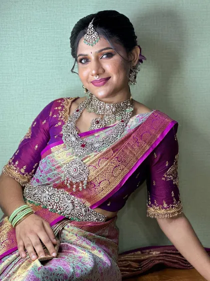 A full-length view of the model in the purple and green silk saree, showcasing the beautiful drape and color combination.