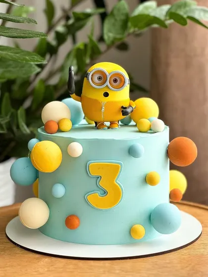 A fun Minion-themed cake for a 3rd birthday. This bright and cheerful cake features a popular Minion character and colorful spheres, perfect for a playful party.