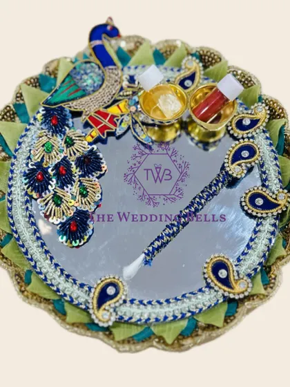 A stunning peacock-themed Rakhi tray with a mirror base. The intricate peacock design and vibrant colors make it a true statement piece.