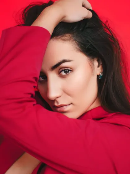 Redefining power and passion. A close-up portrait against a vibrant red background, capturing an intense and confident expression that matches the boldness of the color.
