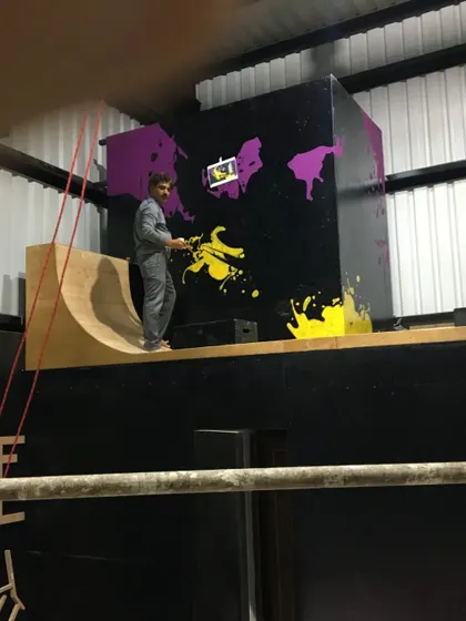 No space is too big or too high. Here, one of our artists works on scaffolding to complete a large commercial mural, showing our capability to handle projects of any scale.