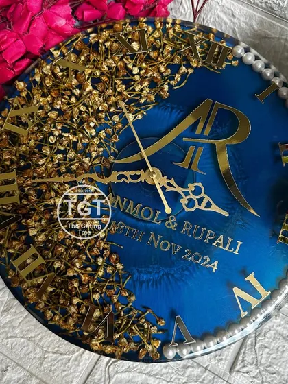 For this 12-inch clock, I used the couple's golden-hued varmala flowers to create a full, lush arc. The design is set against a navy blue base, giving it a very rich and elegant feel.