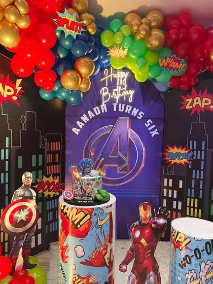 A close-up of our Avengers theme birthday decoration. This view highlights the custom-printed backdrop with the Avengers logo, themed pedestals for the cake, and superhero character standees.