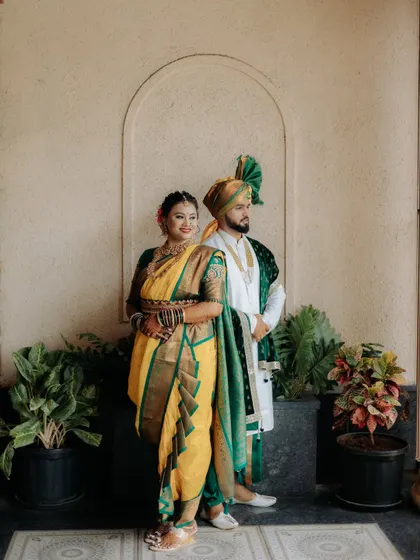 A stylishly posed portrait of the Maharashtrian couple, showcasing their regal wedding attire.