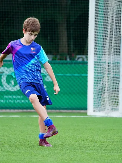 A player focuses on his technique as he passes the ball during a drill.
