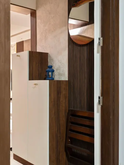 A compact foldable chair tucked into the shoe rack unit in the 'Muditā' foyer, a perfect example of a small but highly practical design choice.