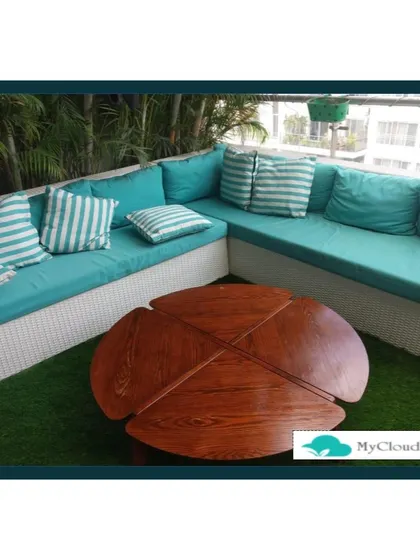 This photo focuses on the comfortable, custom-built L-shaped seating that serves as the centerpiece of a terrace garden. Placed on lush artificial grass, the vibrant turquoise cushions provide a pop of color and create an inviting space for lounging with family and friends.