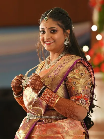 A candid shot from a reception. The rich silk saree is draped to create a flattering silhouette, ensuring the bride looks her best in all her photographs.