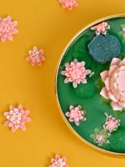 A close-up detail shot of my handcrafted Lotus Pond Urli candle. The vibrant colors and intricate wax flowers make it a stunning centerpiece for any festive occasion, bringing tranquility and elegance to your home decor.
